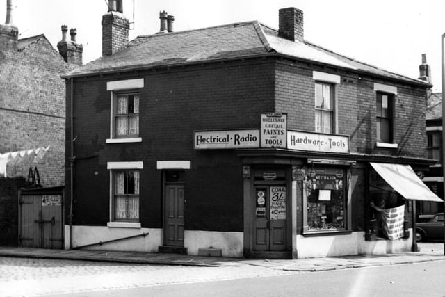 A hardware shop on the corner of Cambridge Road and Vaughan Street in August 1967. Business of Keith and son, selling electrical goods, radios, paint and tools. Signs on the door advertise coal for sale, and paraffin for heaters. To the right is S. Appleson shoe shop, then Oakfield Street is next.