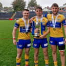 Noah Whittingham, right, with teammates Elliott Fox, left and Harry Smith following Rhinos' reserves Grand Final win against Warrington Wolves last September. Picture by Peter Smith.
