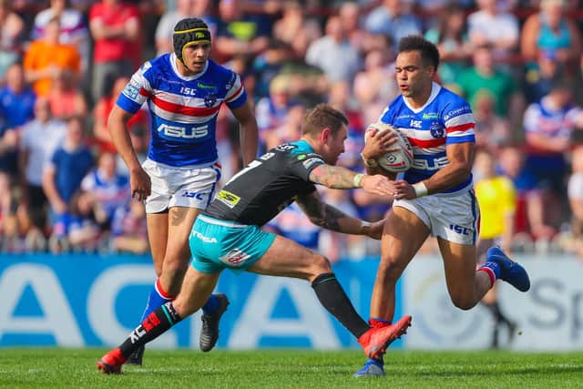 Mason Caton-Brown, of Wakefield Trinity, is tackled by Leeds Rhinos' Richie Myler during a Super League game at Belle Vue in April, 2019. Picture by Alex Whitehead/SWpix.com.