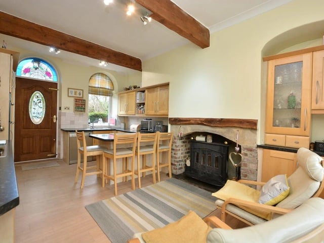 A lovely living space has ornate cornicing and a gas fire inset into the wall, as well as double doors leading through to a further versatile reception room.