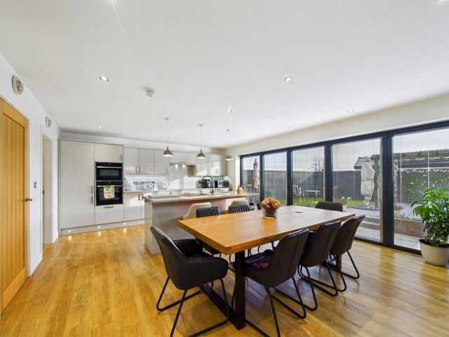 Under floor heating sits beneath the Karndean flooring, and bi-folding doors with fitted blinds open to the enclosed rear garden.