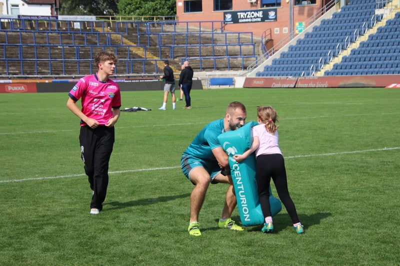A young fan pits her strength against Rhinos' Shooting Star Jarrod O'Connor at Rhinos' sponsors' training day.
