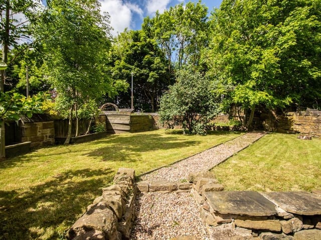 Pathways and seating areas feature within the lawned garden areas.