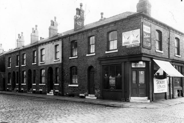 Double fronted brick built back-to-back terraced houses in Hartley Terrace. The shop on the corner is numbered as 16 Sydenham Street and was an off licence run by Bessie Richmond. Pictured in March 1965.