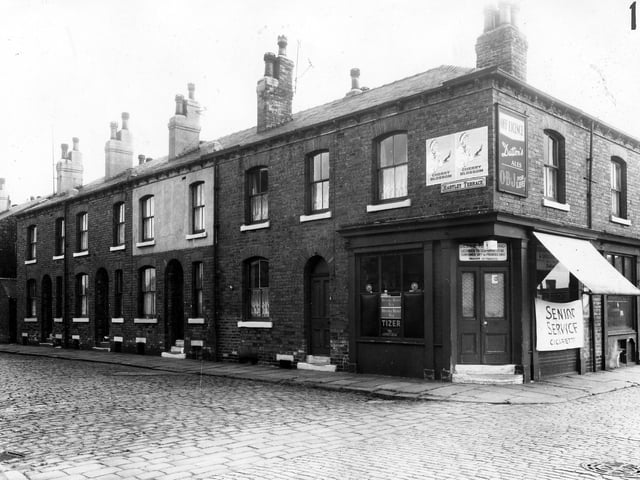 Double fronted brick built back-to-back terraced houses in Hartley Terrace. The shop on the corner is numbered as 16 Sydenham Street and was an off licence run by Bessie Richmond. Pictured in March 1965.