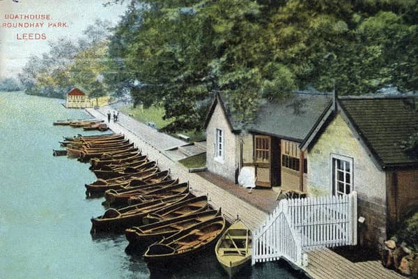 A colour-tinted postcard view of Roundhay Park showing Waterloo Lake with one of its two boathouses in the foreground. A large number of boats are lined up along the edge of the lake. The postcard is franked with the date May 29, 1908.