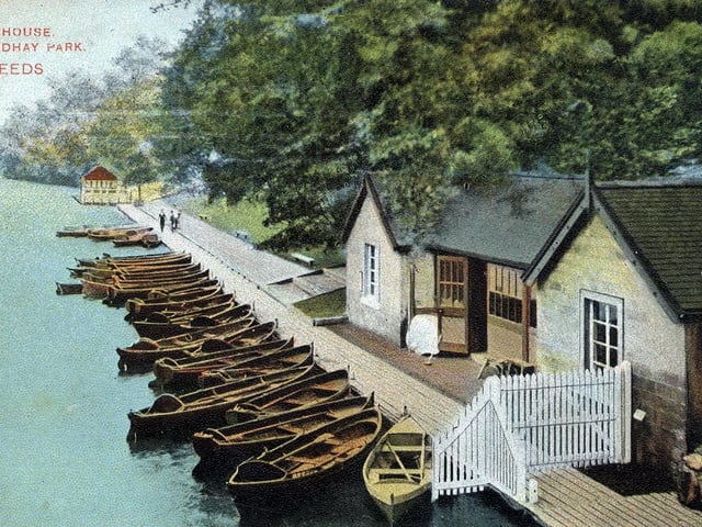 A colour-tinted postcard view of Roundhay Park showing Waterloo Lake with one of its two boathouses in the foreground. A large number of boats are lined up along the edge of the lake. The postcard is franked with the date May 29, 1908.