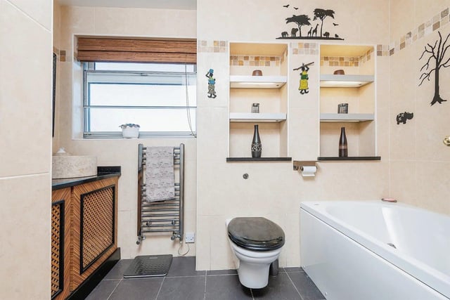 A generous size bathroom has a fully tiled four piece suite comprising a panel bath with shower head, separate shower cubicle with power jet shower, toilet and wash basin.