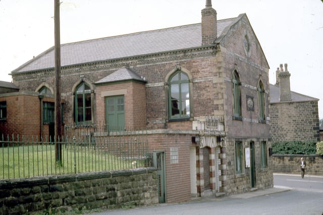 Churwell Town Vestry which stands at the junction with Elland Road and Victoria Street, looking from Victoria Street in August 1968. A man can be seen crossing Elland Road and part of Churwell post office in Clarendon Terrace is visible behind him. The Town Vestry was built in 1863 on the site of the old village school and later became known as the Town Hall. It was a place where the people of Churwell met to discuss and organise the village affairs. In 1901 it became the Sunday School of All Saints Church. Since the 1970s it has been run as Churwell Community Centre.