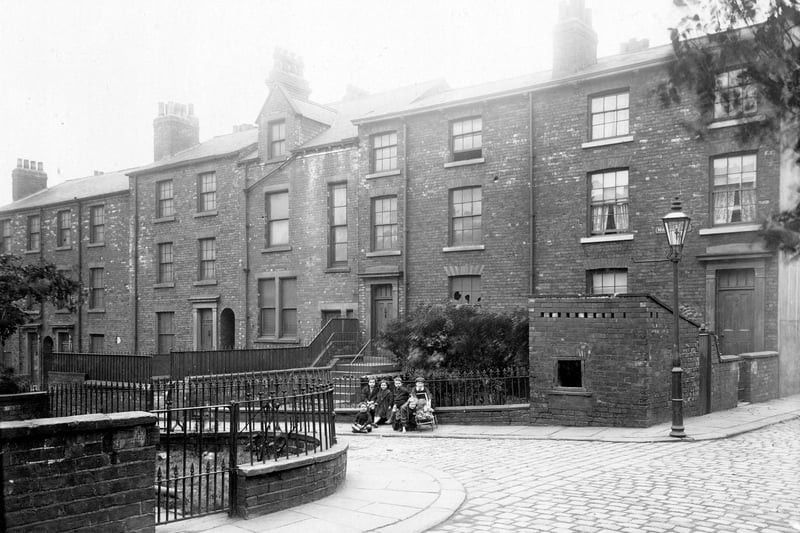 Located off south Carnaby Street, this is the West side. Terrace houses with varying features and of different layout and size, with gardens. A group of children are posing for the camera in period dress. Pictured in August 1913.