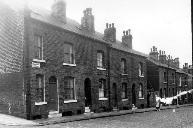 A child is peering over a safety gate in this view seen from Husler View, Goxhill Street, looking at the even numbered side, in the direction of Buslingthorpe Lane in July 1958.