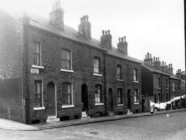 A child is peering over a safety gate in this view seen from Husler View, Goxhill Street, looking at the even numbered side, in the direction of Buslingthorpe Lane in July 1958.