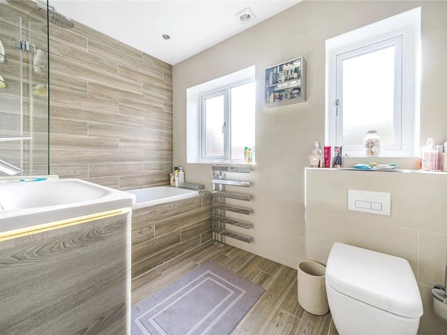 There is a stylish appointed house bathroom that has a bath, toilet and sink.