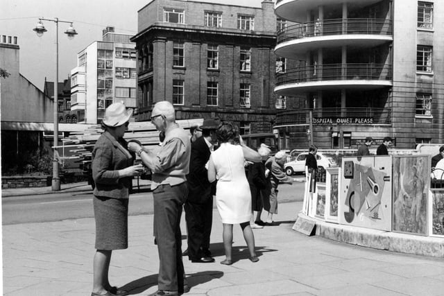 People enjoy an exhibition on Calverley Street in July 1967. Leeds General Infirmary can be seen in the background.