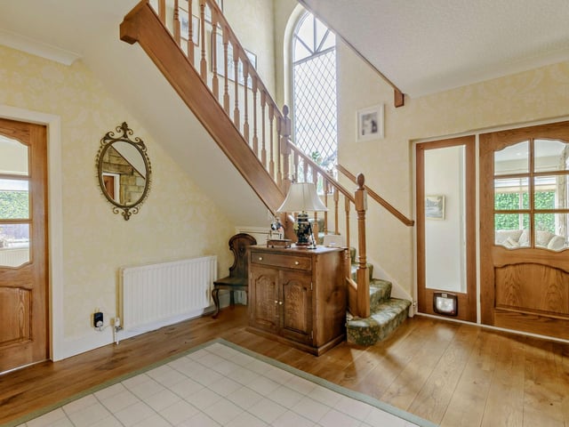 The entrance hall has an oak floor and is overlooked by a gallery landing.