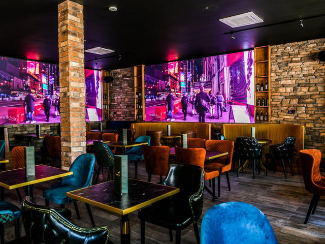 There are stone walls, four large TV screens and a wooden theme throughout.