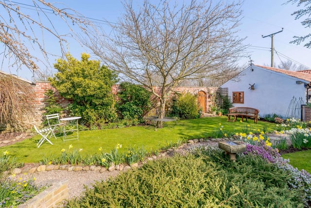 There's a large lawned rear garden, with an orchard, an area of timber decking, and a side lawn. A walled front garden is lawned with flower beds