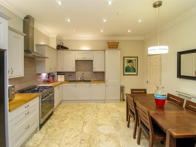 This large kitchen with diner has fitted units with solid wood worktops, and features a range cooker with integrated appliances.