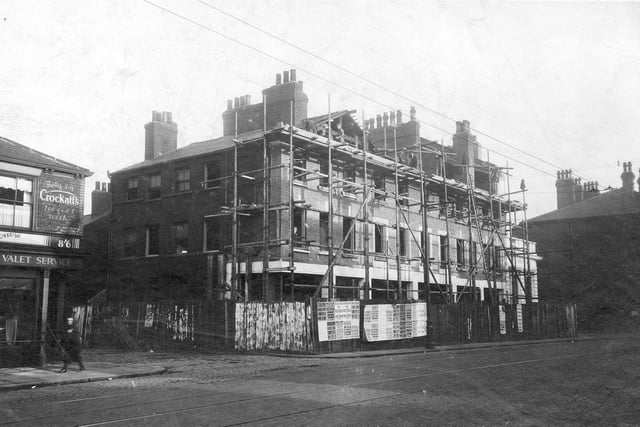 A view from junction with Pitfield Street looking down towards Stafford Street in October 1930. Scaffolding up at the shops which are being altered. Various posters have been put on the fence showing the headlines from different newspapers.