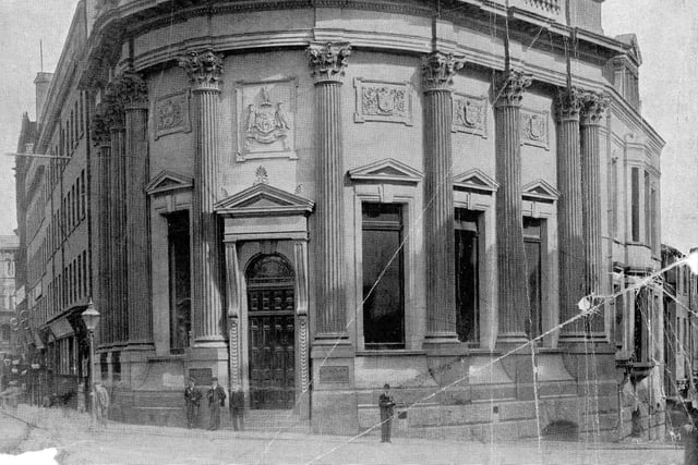 The headquarters of the Yorkshire Banking Company on the corner of Boar Lane and Bishopgate pictured in November 1899. The building opened in June 1899 and was designed by W.W. Gwyther. Built from granite, the building is ornamental with Corinthian columns and balustrading. The statues seen on either side of the roof represent Manufacture and Agriculture. Carved panels above the windows depict the coats of arms of prominent towns and cities where other branches of the Yorkshire Banking Company were situated. The City of Leeds insignia is above the door showing the three owls, three stars and the fleece. The building is topped with a copper dome which is 40 feet in diameter with an iron corona containing a skylight in the centre.