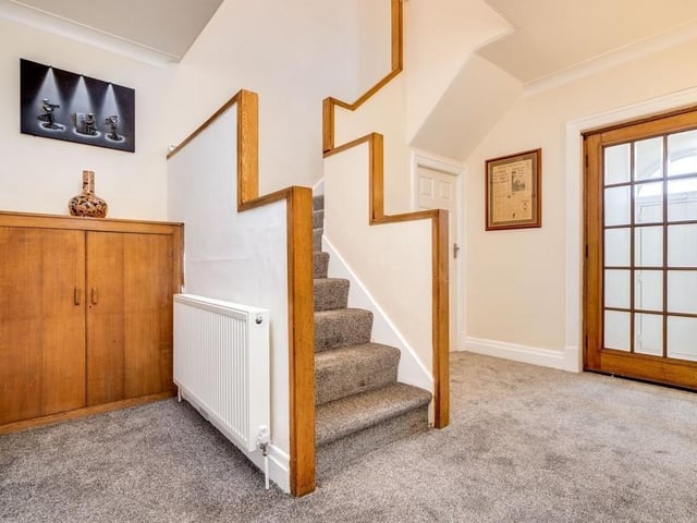 The hallway has a feature staircase leading up to a first floor gallery landing.