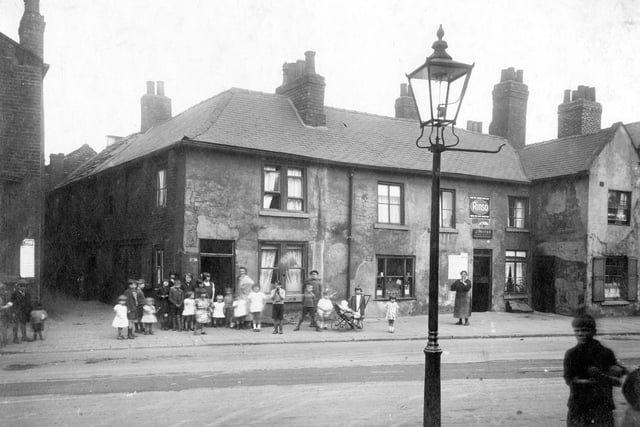 Children and woman pose outside buildings and entrance to Taylors Place in August 1929. The shop to the left is number 10 Church Street and the premises of John Porter, tobacconist.
