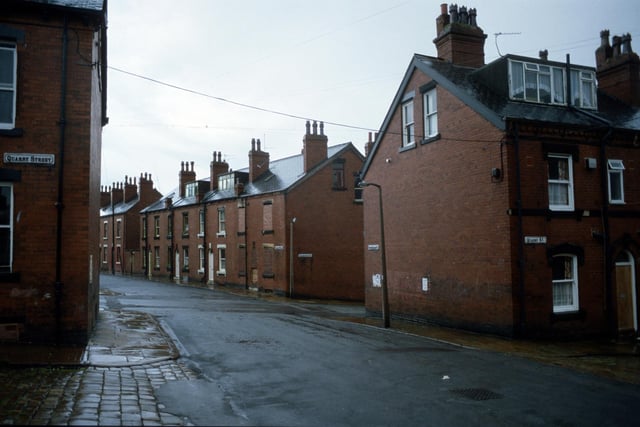 Looking east along Cross Quarry Street from the junction with Quarry Street in August 1985. After the next junction (Christopher Road) Cross Quarry Street becomes Glossop Street where a row of red brick terraced houses are seen. In the foreground are nos. 26 (left) and 24 (right) Quarry Street which are back-to-backs with 25 and 23 Christopher Road.