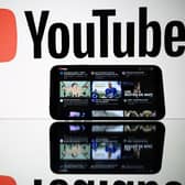 A picture taken on October 5, 2021 in Toulouse shows the logo of Youtube social media displayed by a screen and its website displayed by tablet. ) (Photo by LIONEL BONAVENTURE/AFP via Getty Images)