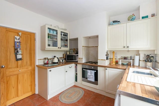 The kitchen features a modern oven and hob, ample storage space and a range of shaker style units.