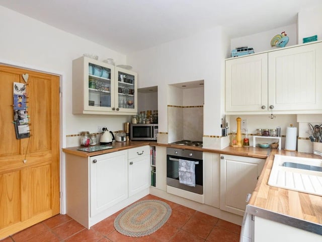 The kitchen features a modern oven and hob, ample storage space and a range of shaker style units.