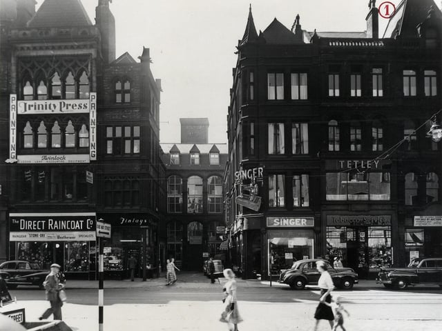The south side of Boar Lane looking down White Horse Street in July 1955. Many shops can be seen including Trinity Press Printers, The Direct Raincoat Co., Finleys tobacconists, Singers Sewing Machine shop, Tobacco Services and an Auction room.