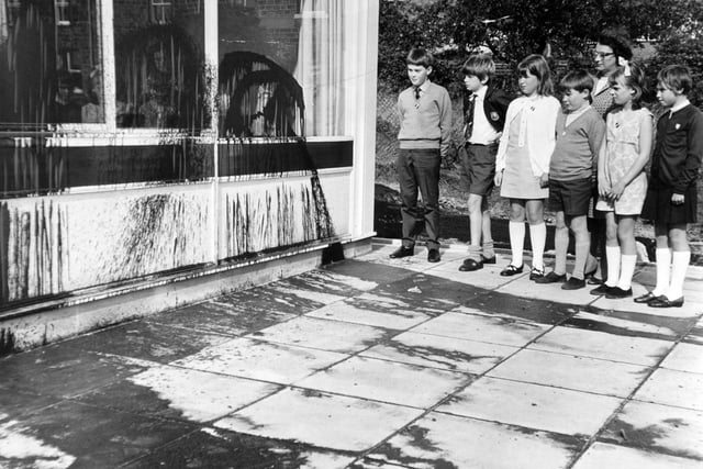 Pupils of Greenhill County Primary Junior School look at the tar that has been sprayed by vandals on their new school building in October 1969.