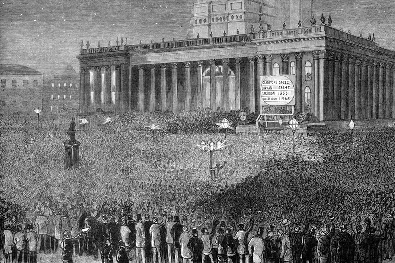 Crowds gather outside Leeds Town Hall to hear the results of the General Election in April 1880. A board has been put up  to the right of the Town Hall steps. Votes for candidates were as follows; Gladstone: 24,622, Barran: 23,647, Jackson: 13,331 and Wheelhouse: 11,965. This engraving was first published in the Leeds Graphic.