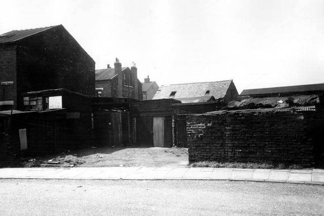 The entrance to a yard of garages off Ascot Terrace. In the distance on the left can be seen the gable ends of back-to-back terraced houses.