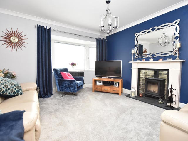 The lounge has a window to the front, quality carpet, ceiling coving and a feature fireplace with inset woodburning stove.