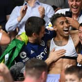 BRENTFORD, ENGLAND - MAY 22: Raphinha of Leeds United celebrates with the fans after avoiding relegation following victory in the Premier League match between Brentford and Leeds United at Brentford Community Stadium on May 22, 2022 in Brentford, England. (Photo by Alex Davidson/Getty Images)