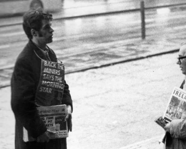 Two newspaper sellers in Leeds city centre engaged in a conversation. The man on the left is selling copies of the Morning Star, a left-wing tabloid newspaper which, until 1966, was known as 'The Daily Worker'. As seen here, the Morning Star was in support of the National Union of Mineworkers during the strikes of the 1970s and 80s. The board strung around the young man's neck states 'Back the Miners Says the Morning Star'. At the time the photograph was taken the miners were part way through a seven week strike for better pay.