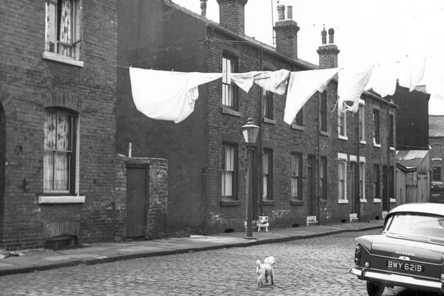 Oatland Place in August 1967. A dividing wall separated Oatland Place from Meanwood Terrace here. The outline of 10 Meanwood Terrace can be seen as the dark gable end. On the right edge is a glimpse of Servia Grove. Meanwood Terrace was accessed from Servia Grove. In the bottom right corner, the Singer car was parked outside number 12 Oatland Place.