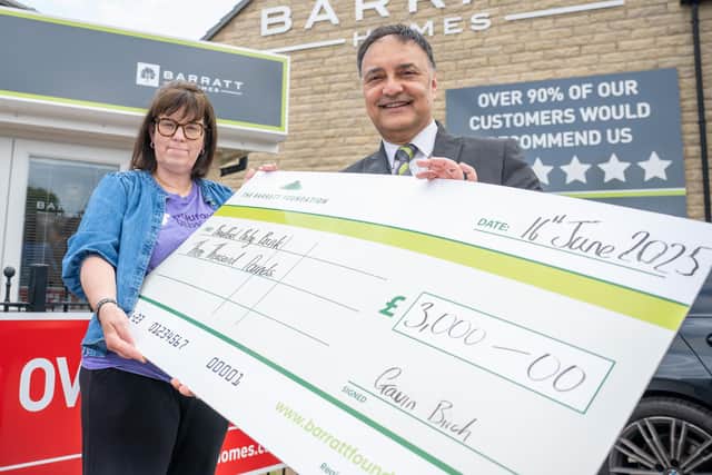 Vickie from Bradford Baby Bank receiving her check from Kinder from Barratt Homes