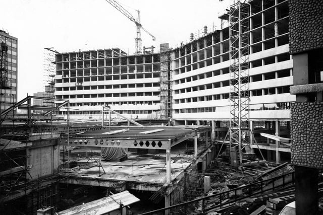 This view looks across to the construction site of Merrion House from the Wade Lane side. The foreground, built to a lower level, is the location of Morrisons. These were built as an extension to the Merrion Centre, opening around 1972.