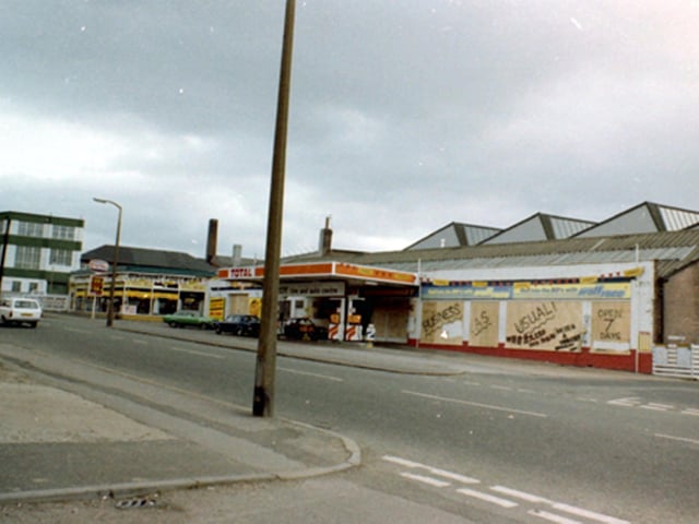 Harehills Lane showing Troy Garage, boarded up for protection as a result of riots in the area, but proclaiming Business As Usual.