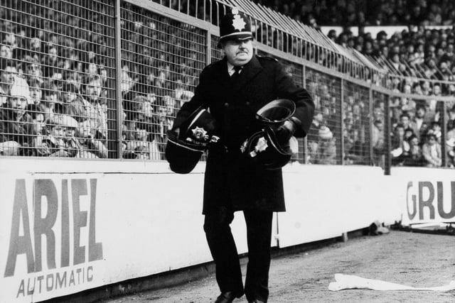 Isolated trouble broke out on the terraces at Elland Road in Februart 1987. Pictured is a policeman collecting helmets which were knocked off.