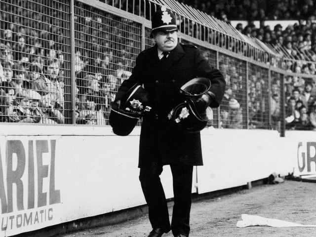 Isolated trouble broke out on the terraces at Elland Road in Februart 1987. Pictured is a policeman collecting helmets which were knocked off.