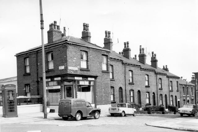 South Mount Street at the junction with Cemetery Road in July 1964. From the left at no 60 is Jim's Gent's Hairdresser's with the striped barber's poles at either side of the door. An electricity service van is parked outside. The next five houses are through red brick terraced with arched doorways and sash windows.