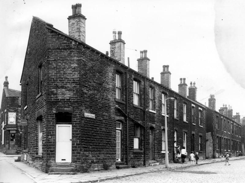 A long view of Albert Street taken from the junction with Stanningley Road in July 1968. Parents and children are gathered in the street outside number 5. A corner shop with a white door is numbered as 556 Stanningley Road and in the background left, is the corner shop, Lodges at the corner bottom of Waterhouse Terrace at number 560.
