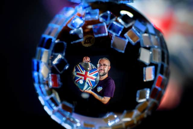 Leeds based mirrorball artist and signwriter Keiran Hadley with his mirrorball for American singer, songwriter, Katy Perry on her current world tour 'The Lifetimes Tour'. Pop icon Kylie Minogue and musician Peter Hook own mirrorballs painted by Keiran. Photograph by Tony Johnson.