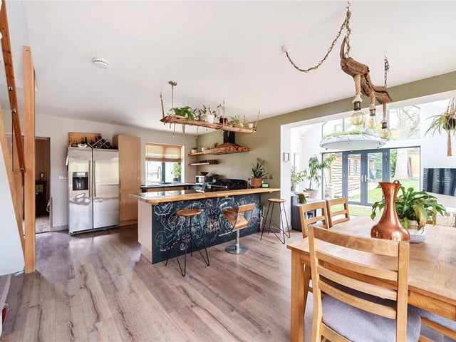 There is a stunning open plan dining/kitchen fitted with modern U-shaped wall and base units, with a breakfast bar.