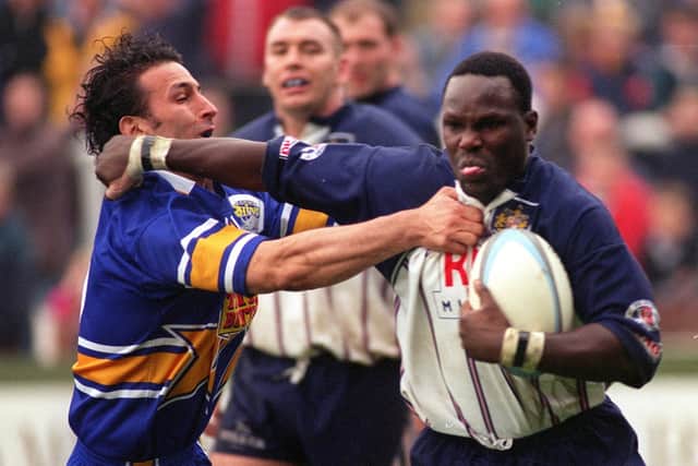 Eddie Rombo, right, playing for Featherstone, is tackled by Leeds' Phil Hassan. Picture by Steve Riding.