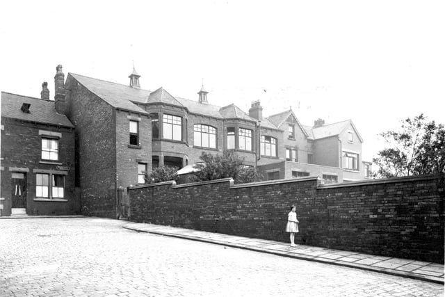 Front view of East End Park Working Men's Club, with grounds. To the left is Raincliffe Terrace. A girl is standing next to the wall. Pictured in June 1935.