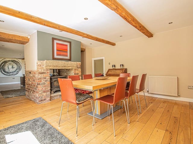 Spaces within this home are zoned effectively by such means as a central stove within a stone and brick surround.